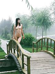 Asian babe posing naked outdoor.