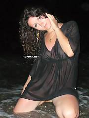 Curly black haired mature woman flashing pussy up-skirt at the sea and spreading legs and pussy lips wide in sea water