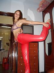 Hot nymph in red pants undresses and poses naked on bed.