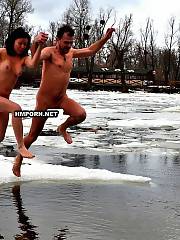 Crazy russians swim in cold water during the winter days, fine tradition of Epiphany religious holiday, watch nudists and naturist men and women swmming nude in ice hole