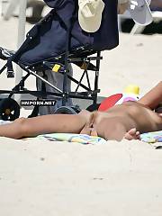 Nudist girls sunbathing nude at public crowded beaches & spreading legs wide to get a ideal tan & tease strangers passing by