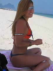 Very sweet girlfriend enjoying sunny days on vacation  teasing boyfriend by exposing him a striptease